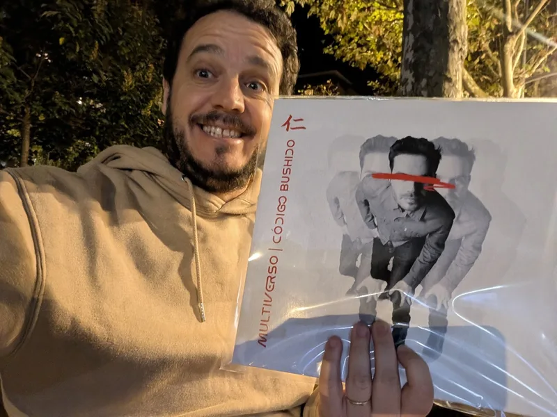 El autor, sonriente, de noche en una terraza, con el falso vinilo de «Multiverso» todavía en su funda de plástico.