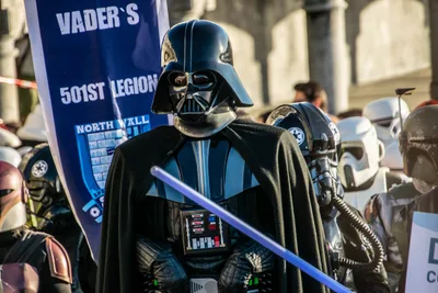 Darth Vader, con el sable de luz, delante del estandarte de la Legión 501 y de otros personajes imperiales.