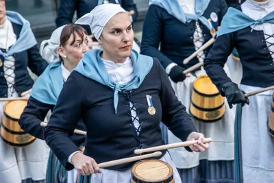 Una aguadora seria toca la barrica entre sus compañeras.