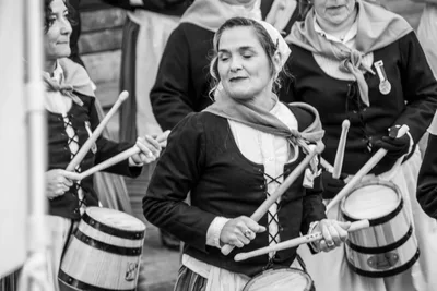 En blanco y negro, una aguadora toca la barrica con los ojos bajos.