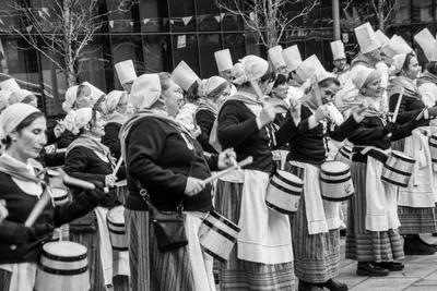 En blanco y negro, las aguadoras tocan en fila con las barricas colgadas.