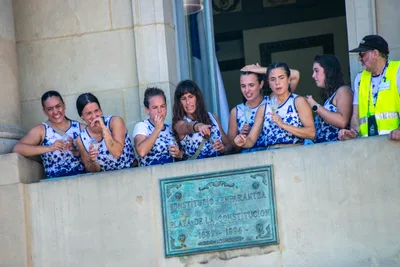 Las remeras se asoman al balcón entre risas, sobre la placa de «Konstituzio enparantza · Plaza de la Constitución».