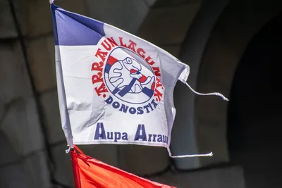 Una bandera de Arraun Lagunak Donostia con el lema «Aupa Arraun» ondea sobre la gente.