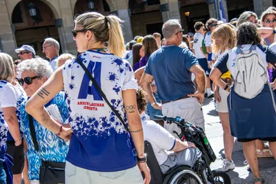 Una aficionada rubia de espaldas, con la gran «A» del club en la camiseta, entre la gente.