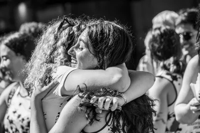 En blanco y negro, dos mujeres se abrazan en medio de la plaza.