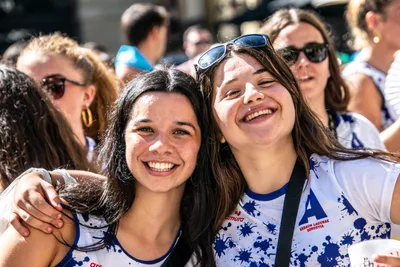 Dos chicas con la camiseta del club se abrazan y se ríen.