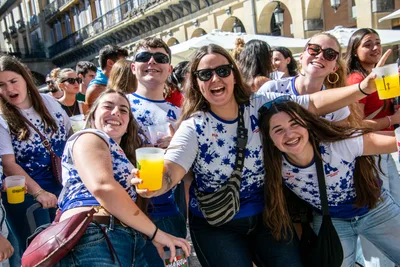 Un grupo de aficionadas brinda con vasos de cerveza bajo las sombrillas de las terrazas.