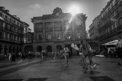 En blanco y negro, la Plaza de la Constitución a contraluz, con el sol detrás del antiguo ayuntamiento.