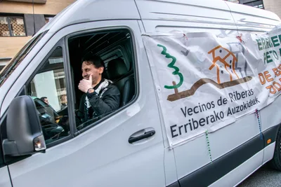 Una furgoneta con la pancarta de Vecinos de Riberas · Erriberako Auzokideak abre el desfile.