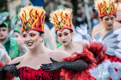 Dos jóvenes con corona de llamas y vestido rojo con volantes.