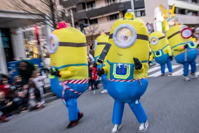 Comparsa de minions hinchables cruzando la calle a la carrera.