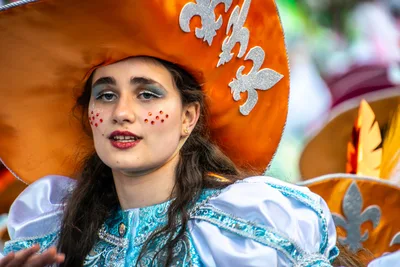 Retrato de una joven con sombrero naranja de flor de lis y vestido turquesa.
