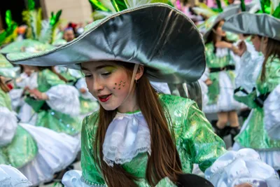 Joven con sombrero verde metálico y vestido verde de volantes, en pleno baile.