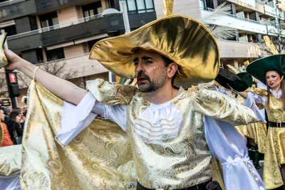 Un mosquetero de dorado abre la capa con los dos brazos.