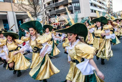 Comparsa de mosqueteros dorados y verdes bailando a la vez.