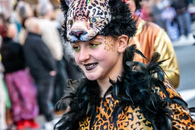 Joven con tocado de leopardo y boa de plumas negras.