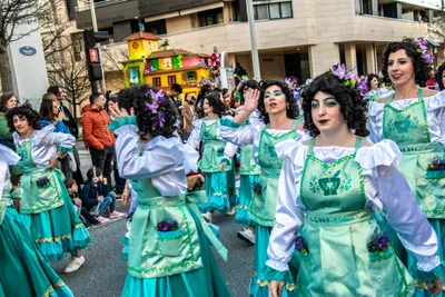 Comparsa de verde agua con delantal bordado y flores en el pelo.