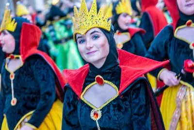 La Reina Malvada con corona dorada y capa roja y negra, cerrando el desfile.