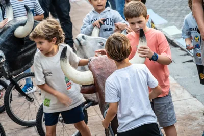 Niños alrededor de los toricos del encierro, armazones de toro con cuernos blancos.