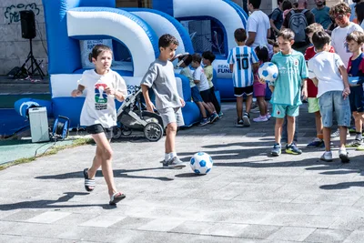 Niños jugando con un balón delante de un hinchable de la Real Sociedad Fundazioa.