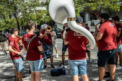 La Lau Katu Txaranga en corro en la calle, con camisetas granates y un sousafón blanco.