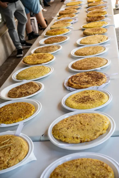 La fila de tortillas vista desde un extremo de la mesa, hasta perderse al fondo.