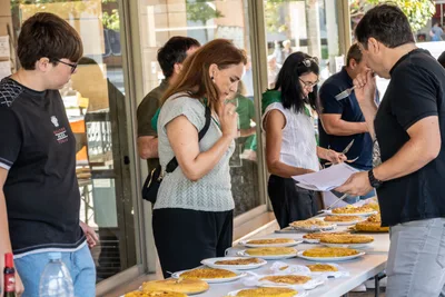 El jurado prueba las tortillas a lo largo de la mesa con las hojas de puntuación en la mano.