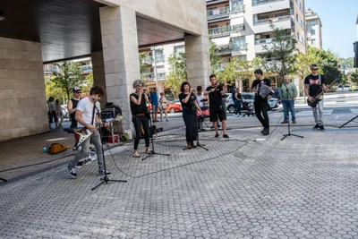 La Elektrotxaranga Riber Rockers toca en la calle, junto a un soportal: voces, violín, acordeón, bajo, guitarra y batería.