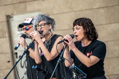 Tres voces del grupo cantan a la vez en dos micrófonos.