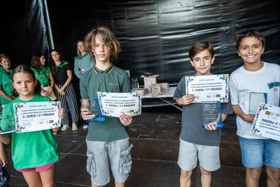 Los premiados del torneo de ajedrez en el escenario, cada uno con su diploma.