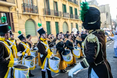 La compañía formada en una calle de casas con balcones: gastadores de amarillo y negro con los tambores colgados y el tambor mayor de espaldas.