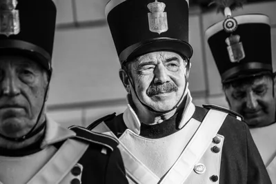 Retrato en blanco y negro de un gastador con bigote, chacó y correaje blanco cruzado al pecho.