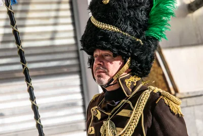 El tambor mayor, con gorro de piel negro y penacho verde, y la casaca con alamares dorados.