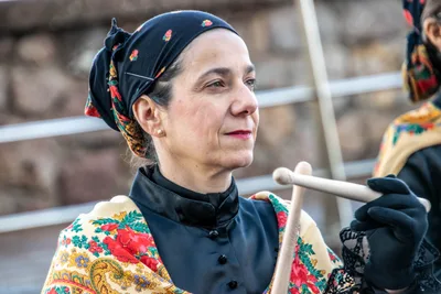 Retrato de una mujer con pañuelo de flores a la cabeza y mantón bordado, baqueta en mano.