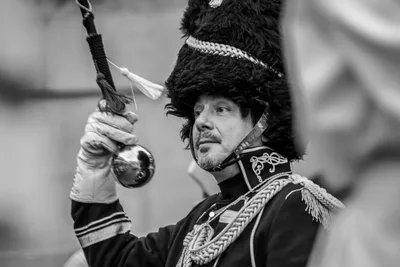El mismo gesto en blanco y negro: el bastón de mando en alto y el gorro de piel.