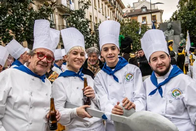 Cinco cocineros brindan con botellines en la calle, ya terminado el paso por la plaza.